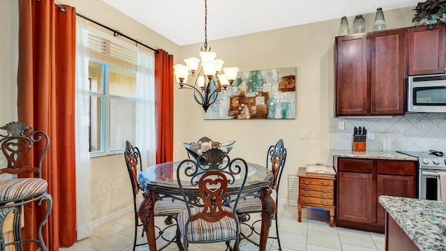 dining room featuring a chandelier, light tile patterned flooring, and baseboards