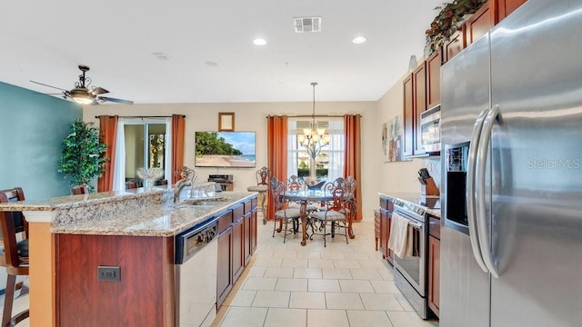 kitchen featuring a sink, visible vents, appliances with stainless steel finishes, a kitchen bar, and pendant lighting