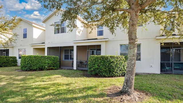 view of property featuring a front lawn and stucco siding