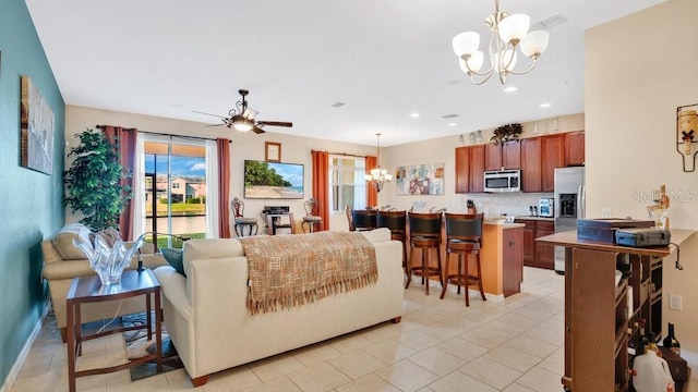 living room with recessed lighting and ceiling fan with notable chandelier