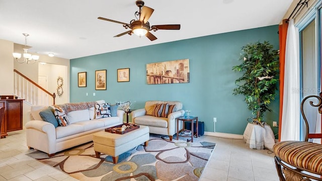 living room with light tile patterned floors, stairway, baseboards, and ceiling fan with notable chandelier