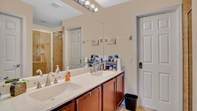 full bathroom featuring double vanity, a shower stall, visible vents, and a sink