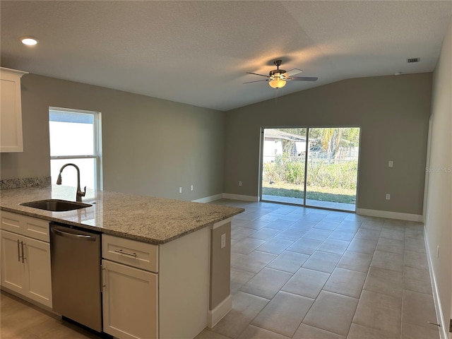 kitchen featuring light stone counters, sink, stainless steel dishwasher, and white cabinets