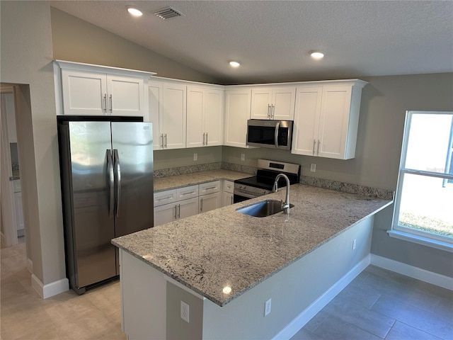 kitchen with appliances with stainless steel finishes, sink, white cabinets, and kitchen peninsula