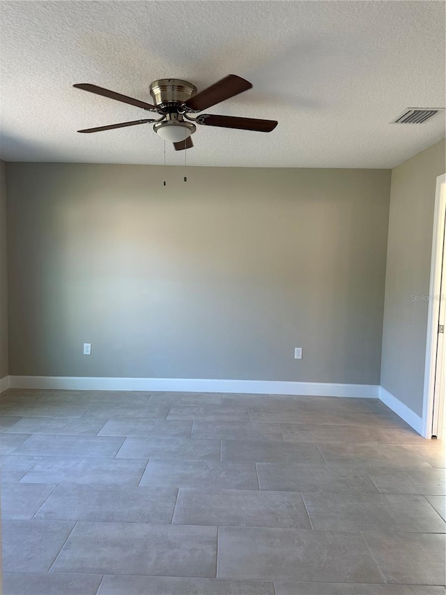 unfurnished room with ceiling fan and a textured ceiling