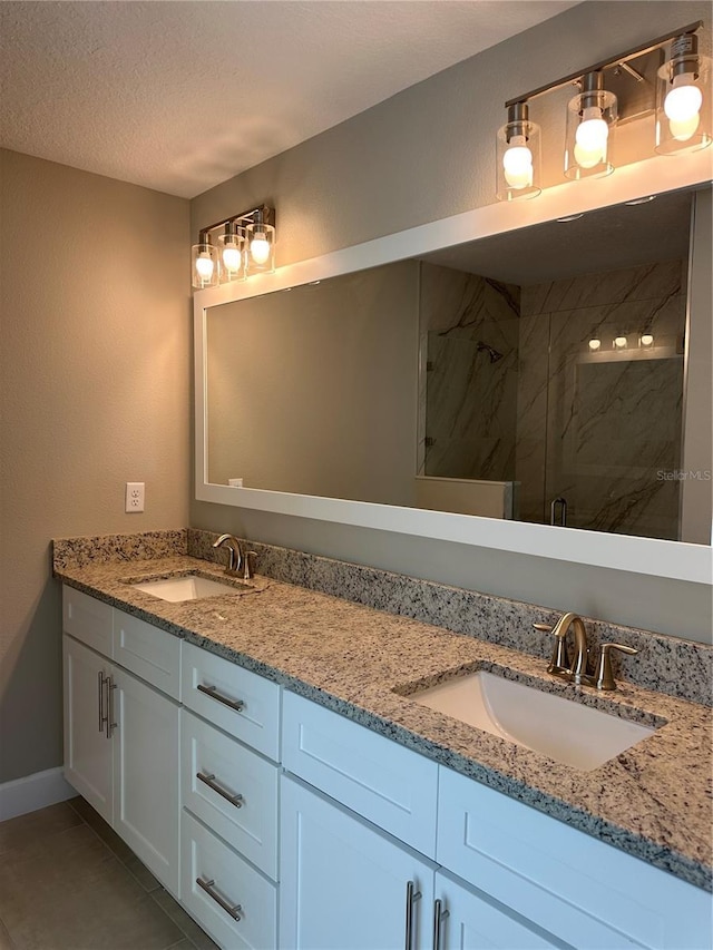 bathroom featuring tile patterned floors, vanity, an enclosed shower, and a textured ceiling