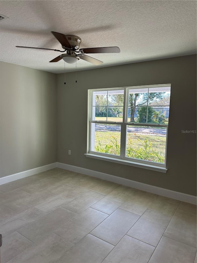 empty room featuring ceiling fan and a textured ceiling