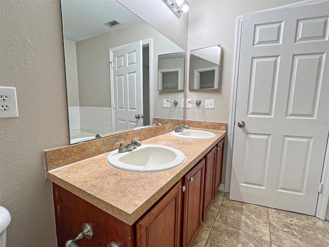 bathroom featuring tile patterned flooring, a textured ceiling, and vanity