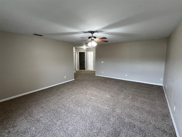 spare room featuring ceiling fan and dark carpet