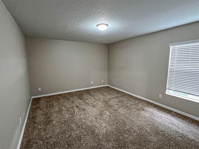 unfurnished room featuring carpet floors and a textured ceiling