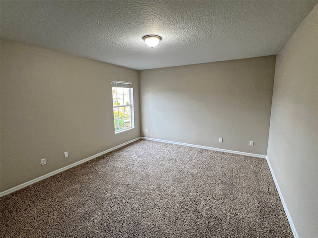 empty room featuring carpet and a textured ceiling