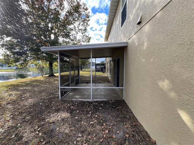 exterior space with a sunroom and a water view