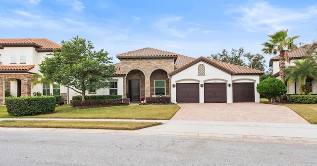 mediterranean / spanish-style home featuring a garage and a front yard