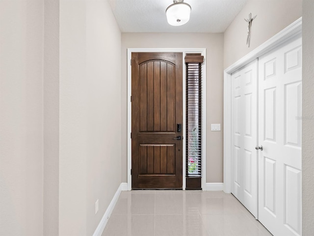 tiled foyer featuring a textured ceiling