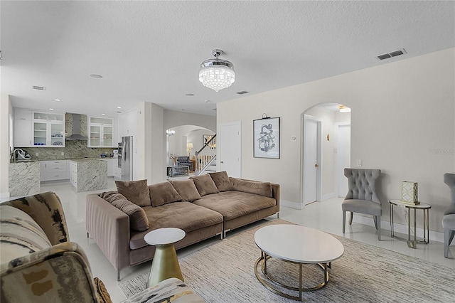 living room featuring a chandelier, a textured ceiling, and sink