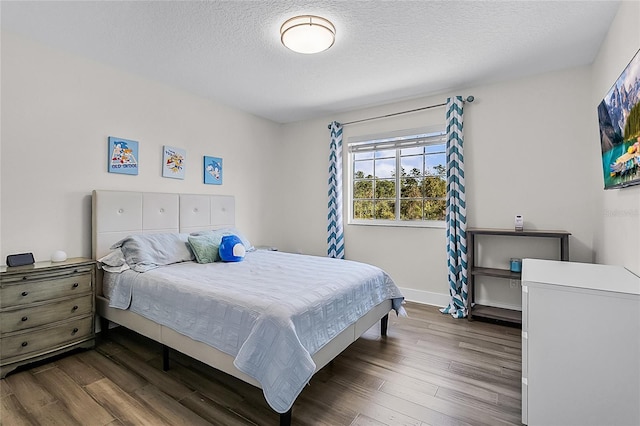 bedroom with a textured ceiling and dark wood-type flooring