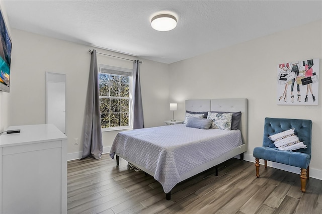 bedroom with hardwood / wood-style floors and a textured ceiling