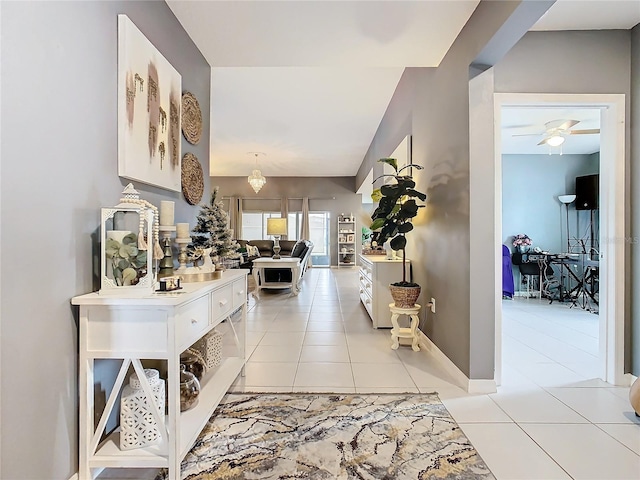 hallway with light tile patterned floors and a chandelier