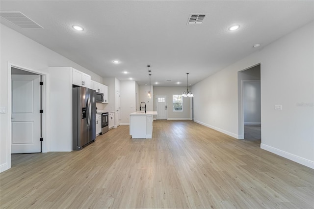 kitchen featuring stainless steel appliances, open floor plan, visible vents, and light wood-style floors