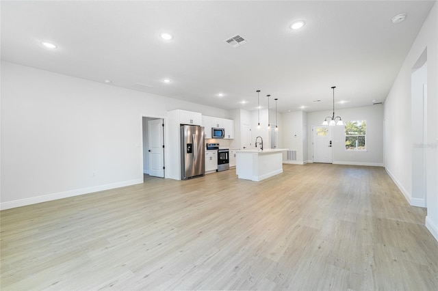 unfurnished living room with recessed lighting, visible vents, light wood-style flooring, a sink, and baseboards