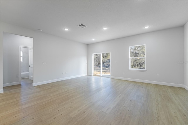 spare room featuring light wood finished floors, baseboards, visible vents, and recessed lighting