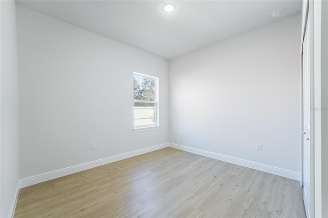 empty room with baseboards and light wood-style floors