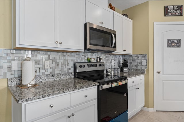 kitchen featuring stone countertops, decorative backsplash, white cabinetry, and appliances with stainless steel finishes