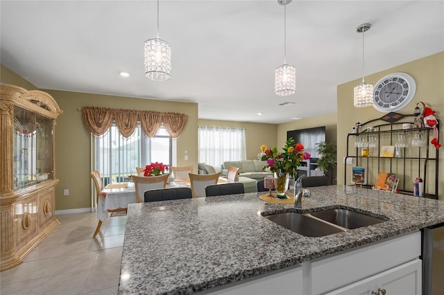 kitchen featuring light tile patterned floors, stone countertops, white cabinetry, and sink