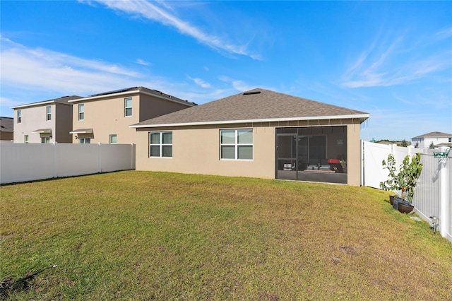 back of property with a yard and a sunroom