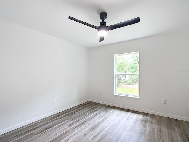 spare room with ceiling fan and light wood-type flooring