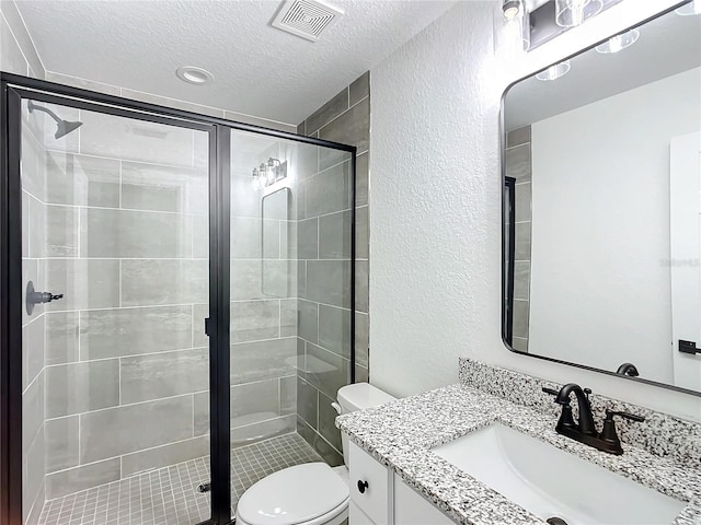 bathroom featuring toilet, an enclosed shower, vanity, and a textured ceiling