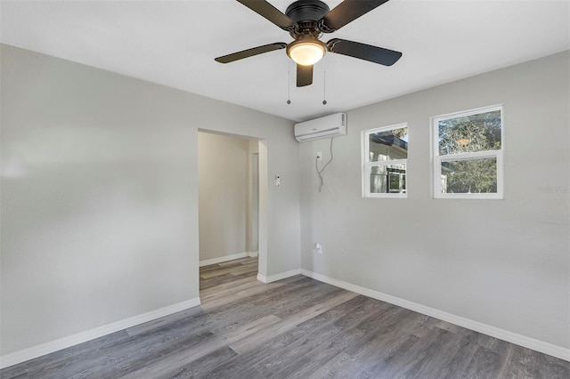 unfurnished room featuring an AC wall unit, ceiling fan, and hardwood / wood-style floors