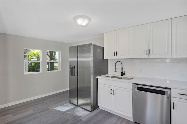 kitchen with white cabinets, backsplash, stainless steel appliances, and sink