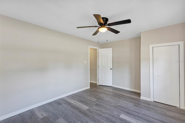 unfurnished bedroom featuring dark hardwood / wood-style flooring, a closet, and ceiling fan