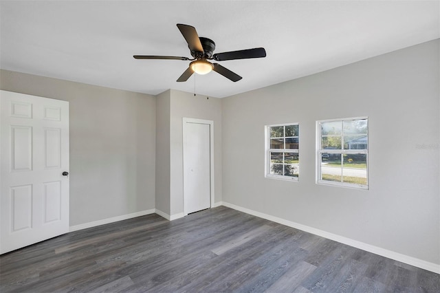 unfurnished bedroom featuring ceiling fan, dark wood-type flooring, and a closet