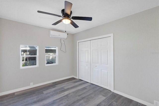 unfurnished bedroom featuring ceiling fan, a closet, dark hardwood / wood-style floors, and a wall mounted air conditioner