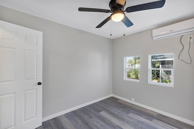 spare room featuring a wall mounted air conditioner, hardwood / wood-style flooring, and ceiling fan