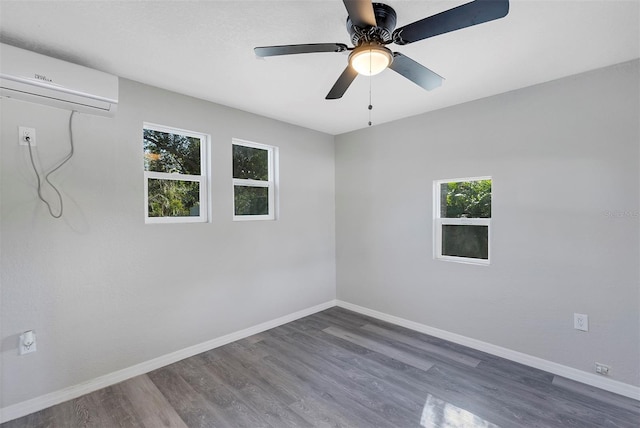 unfurnished room with a wall mounted air conditioner, ceiling fan, and dark hardwood / wood-style flooring