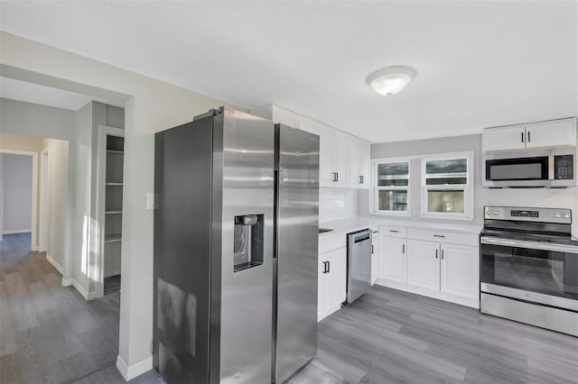 kitchen featuring appliances with stainless steel finishes, white cabinetry, and light hardwood / wood-style flooring