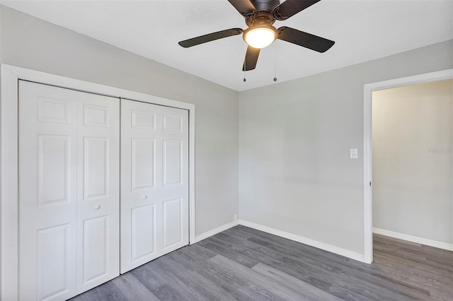 unfurnished bedroom with ceiling fan, a closet, and dark hardwood / wood-style flooring