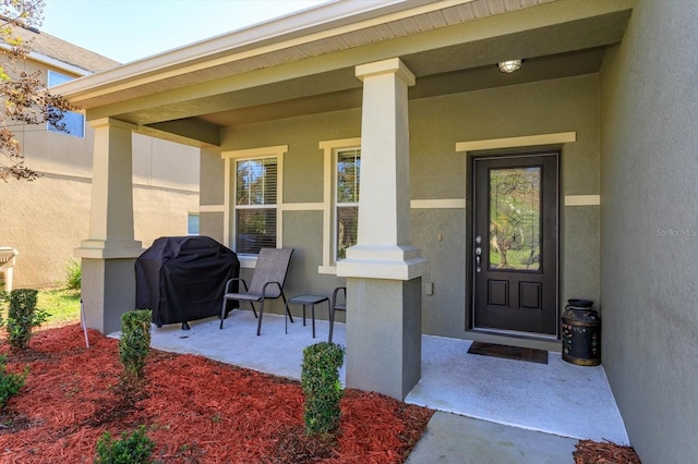 view of exterior entry featuring covered porch