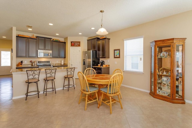 tiled dining area with sink and a textured ceiling