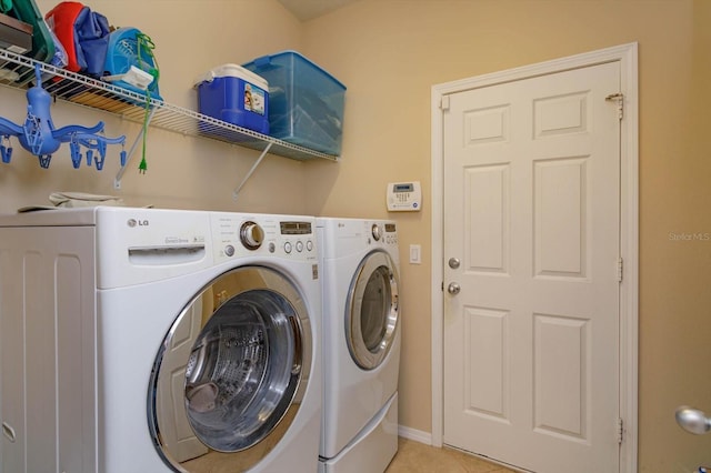 laundry area featuring washing machine and dryer and light tile patterned flooring