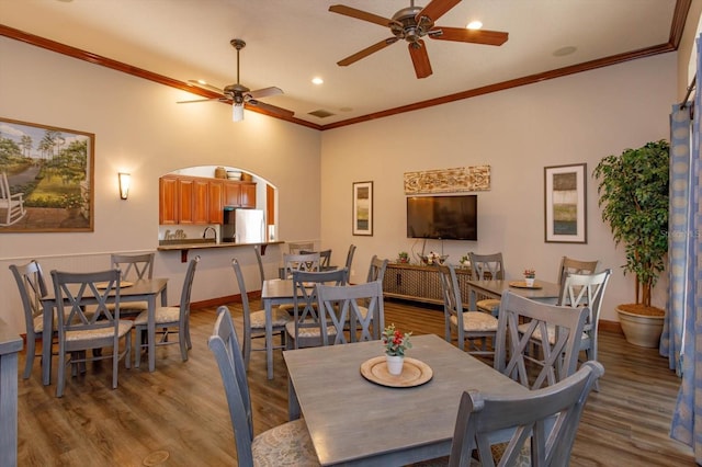 dining room with light hardwood / wood-style flooring, ceiling fan, crown molding, and sink