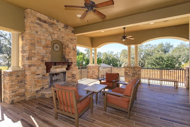 wooden terrace featuring an outdoor living space with a fireplace and ceiling fan