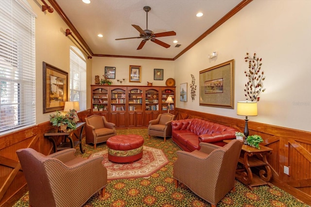 living room featuring wood walls, ornamental molding, and a healthy amount of sunlight