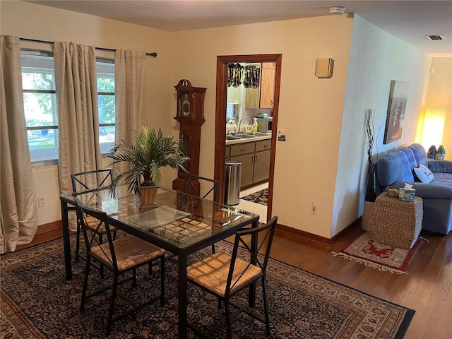 dining room with dark hardwood / wood-style floors and sink