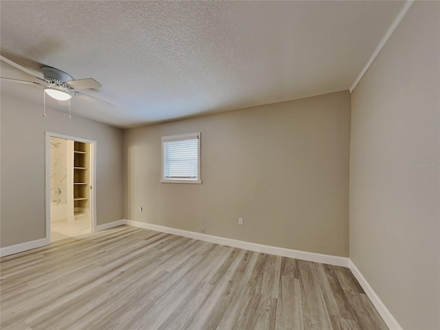 unfurnished room featuring ceiling fan, light hardwood / wood-style floors, and a textured ceiling