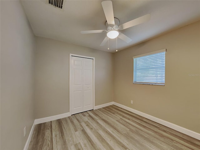 unfurnished bedroom with ceiling fan, a closet, and light hardwood / wood-style flooring