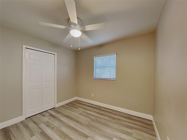 unfurnished bedroom featuring ceiling fan, a closet, and light hardwood / wood-style flooring